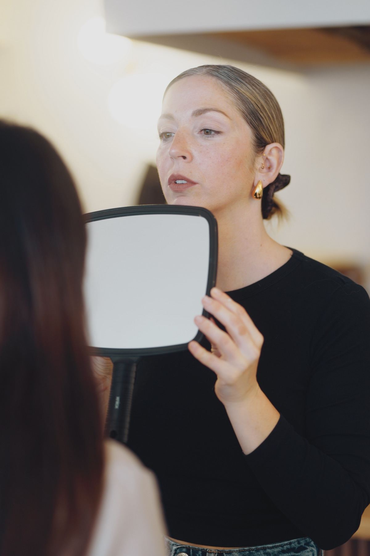Claire Degli-Esposti présente le miroir à sa cliente à la fin d'une séance de maquillage permanent, à Aix-les-Bains